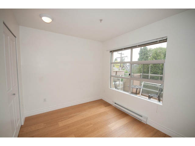 Bright living room with hardwood floors and large windows offering a city view. - 409 - 3023 West 4th Ave., Vancouver West Side