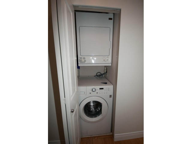 Bright laundry room with stacked washer and dryer, hardwood floors. - 409 - 3023 West 4th Ave., Vancouver West Side