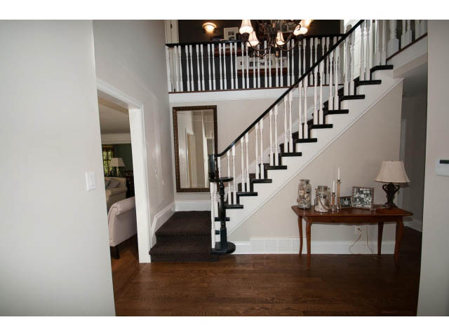 Staircase with white railings and dark wood flooring, leading to a second floor. - 3364 Redfern Pl., North Vancouver