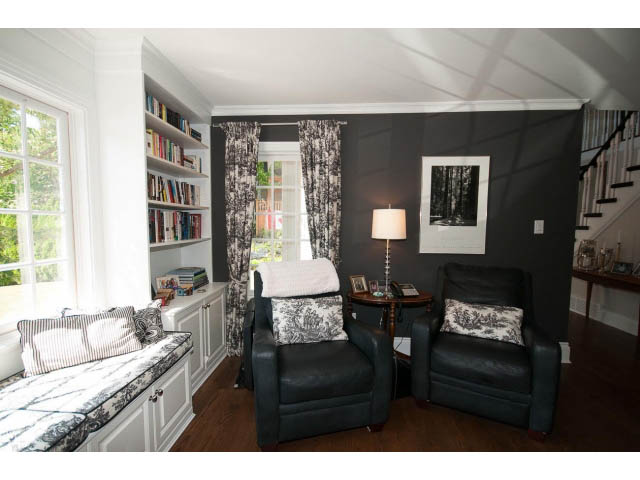 Furnished den with black leather chairs, bookshelves, and patterned curtains. - 3364 Redfern Pl., North Vancouver