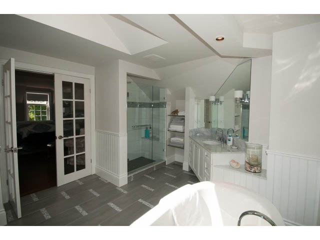 Spacious bathroom with white walls, glass shower, and modern fixtures. - 3364 Redfern Pl., North Vancouver