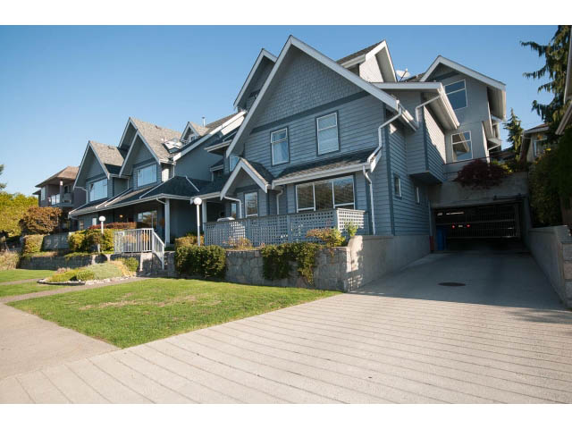 Furnished 2-bedroom townhouse with modern exterior, steps leading to entrance, and lush greenery. - 3 - 260 East 4th St, North Vancouver