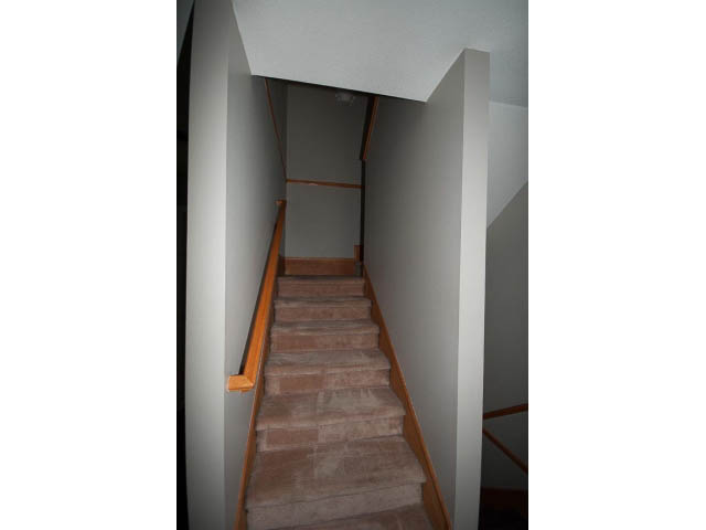 Staircase leading to upper level with carpeted steps and wooden railings. - 3 - 260 East 4th St, North Vancouver