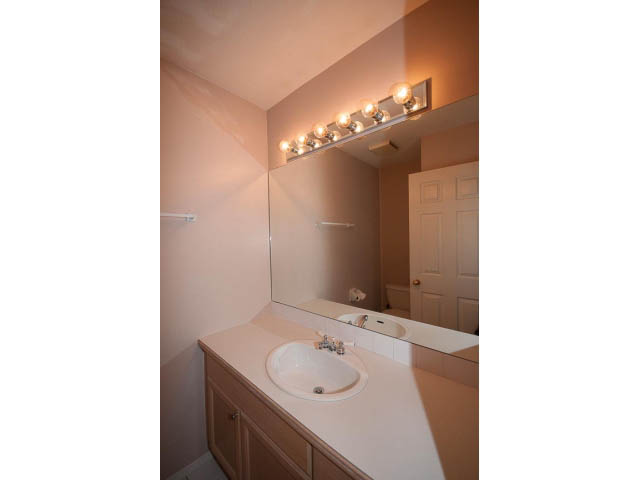 Bright bathroom with white countertop and modern light fixture. - 3 - 260 East 4th St, North Vancouver