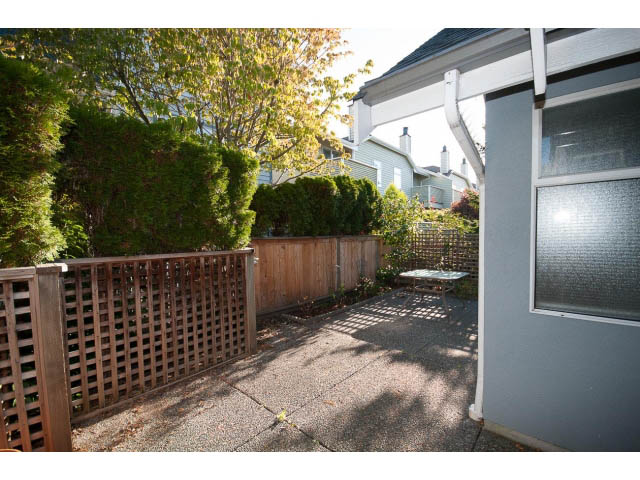 Furnished patio with wooden fencing and lush greenery. - 3 - 260 East 4th St, North Vancouver