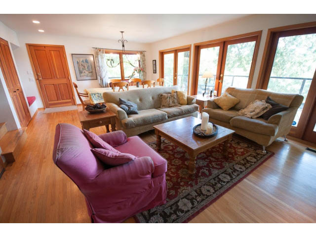 Spacious living room with hardwood floors, large windows, and comfortable seating. - 2795 Panorama Drive, North Vancouver