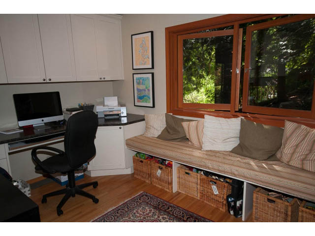 Bright home office with hardwood floors, a desk, and a large window with a view of greenery. - 2795 Panorama Drive, North Vancouver