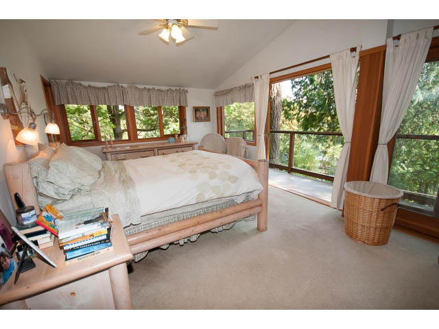 Spacious bedroom with large windows, natural light, and a cozy bed setup. - 2795 Panorama Drive, North Vancouver