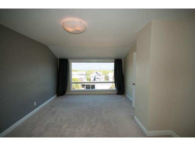 Spacious living room with large windows and neutral carpeting. - 3939 West 11th Ave, Vancouver West Side