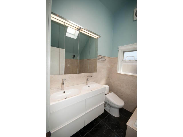 Bright bathroom with white vanity and tiled walls. - 3939 West 11th Ave, Vancouver West Side