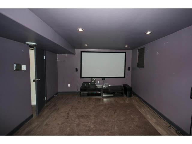 Furnished living room with a large projection screen and hardwood floors. - 3939 West 11th Ave, Vancouver West Side