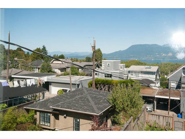 Bright living room with city view and laundry hanging outside. - 3939 West 11th Ave, Vancouver West Side