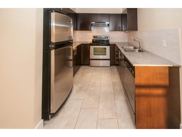 Bright kitchen with granite countertops, stainless steel appliances, and light wood flooring. - 312 - 1633 Mackay Avenue, North Vancouver