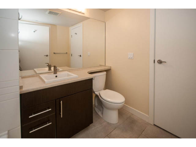Bright bathroom with dark wood cabinets and white countertop. - 312 - 1633 Mackay Avenue, North Vancouver