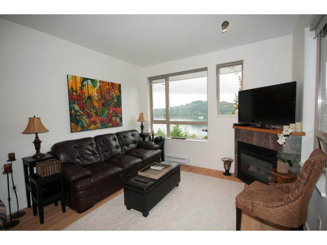 Spacious living room with hardwood floors, city view, and modern furnishings. - 411 - 560 Ravenwoods Dr., North Vancouver