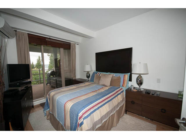 Furnished bedroom with hardwood floors and city view. - 411 - 560 Ravenwoods Dr., North Vancouver