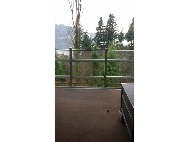 Furnished balcony with city view and wooden railings. - 411 - 560 Ravenwoods Dr., North Vancouver