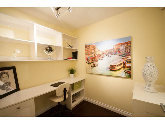 Bright home office with white countertops, cityscape art, and built-in shelves. - 502 - 555 Jervis, Vancouver Downtown