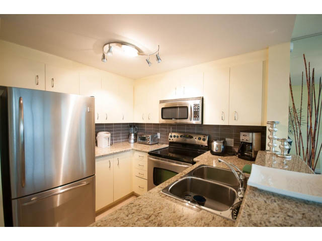 Bright kitchen with granite countertops and stainless steel appliances, modern design. - 502 - 555 Jervis, Vancouver Downtown