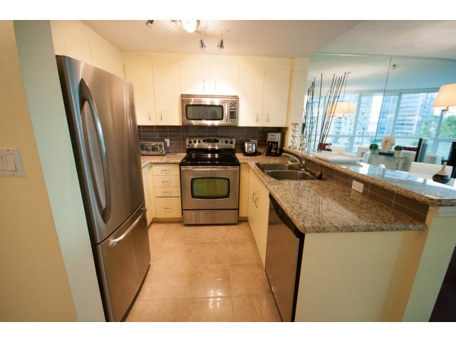 Bright kitchen with granite countertops, stainless steel appliances, and a city view. - 502 - 555 Jervis, Vancouver Downtown