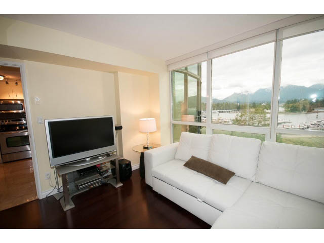 Bright living room with white furniture, hardwood floors, and a city view. - 502 - 555 Jervis, Vancouver Downtown