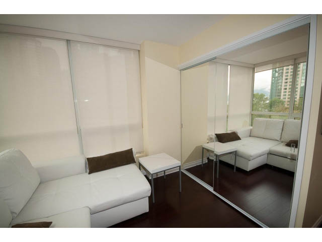 Furnished living room with white leather couch, hardwood floors, and city view. - 502 - 555 Jervis, Vancouver Downtown