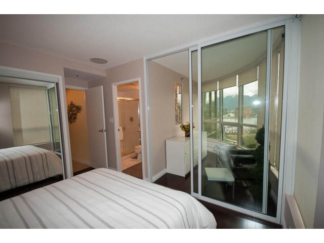 Spacious bedroom with large sliding glass doors, city view, and modern furnishings. - 502 - 555 Jervis, Vancouver Downtown