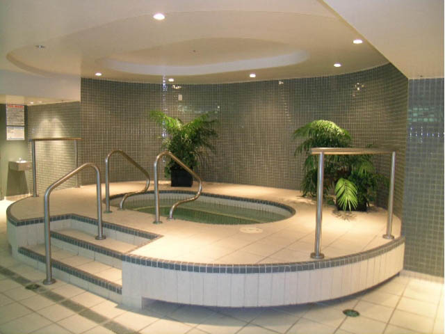 Spacious, modern bathroom with curved sinks, tiled walls, and greenery. - 502 - 555 Jervis, Vancouver Downtown