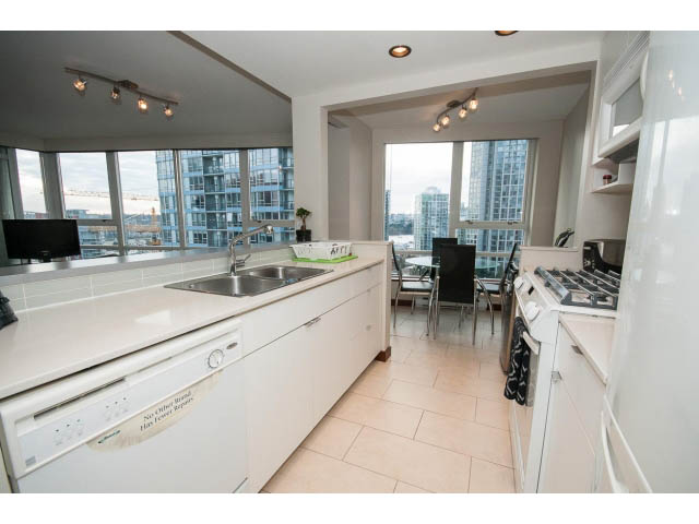 Bright kitchen with white countertops, stainless steel appliances, and a city view. - 1702 - 928 Beatty Street, Vancouver Downtown