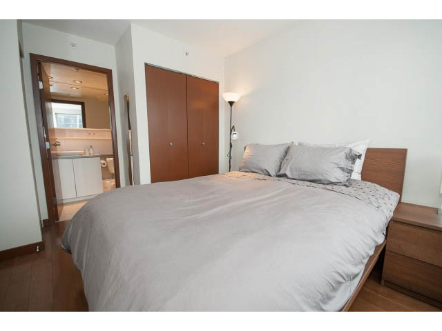 Furnished bedroom with hardwood floors and a modern lamp. - 1702 - 928 Beatty Street, Vancouver Downtown