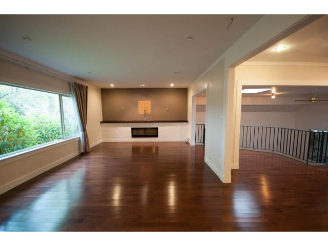 Spacious living room with hardwood floors and large windows. - Main - 4149 Osler St, Vancouver West Side
