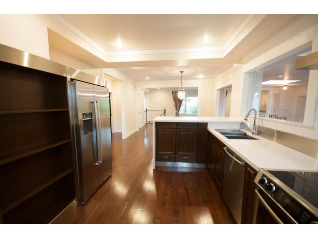 Bright kitchen with white countertops, hardwood floors, and stainless steel appliances. - Main - 4149 Osler St, Vancouver West Side