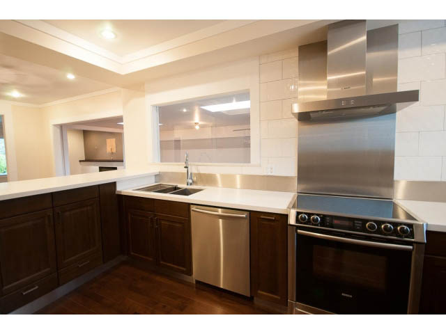Bright kitchen with white countertops, stainless steel appliances, and hardwood floors. - Main - 4149 Osler St, Vancouver West Side