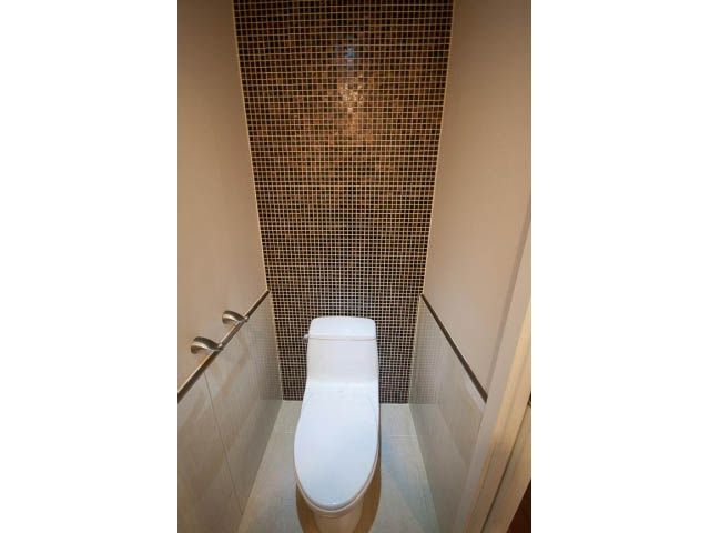 Modern bathroom with mosaic tile wall and sleek toilet. - Main - 4149 Osler St, Vancouver West Side