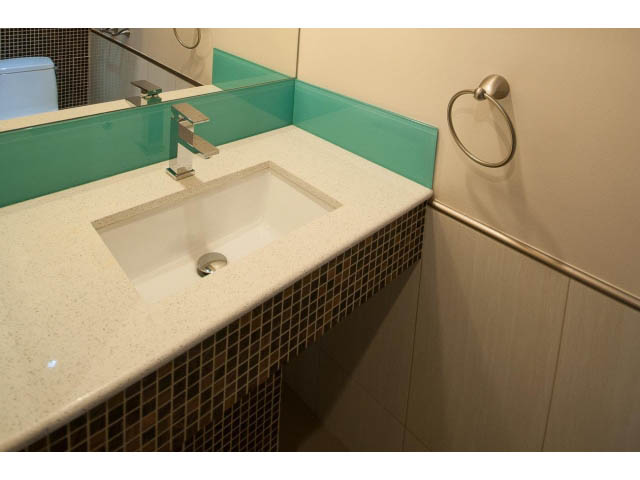 Modern bathroom with white countertop and teal glass splashback. - Main - 4149 Osler St, Vancouver West Side