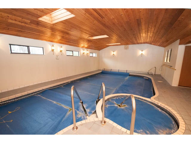 Shared house living room with wooden ceiling, blue carpet, and wall sconces. - Main - 4149 Osler St, Vancouver West Side