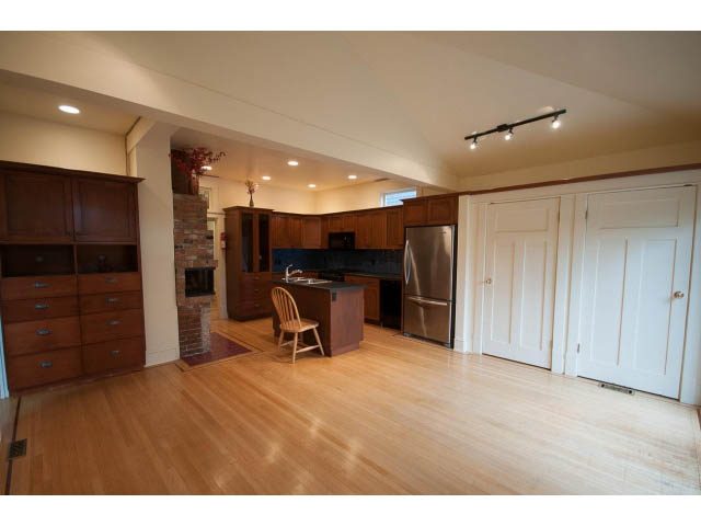 Bright kitchen with hardwood floors, stainless steel appliances, and a cozy fireplace. - 3362 West 3rd Ave, Vancouver West Side