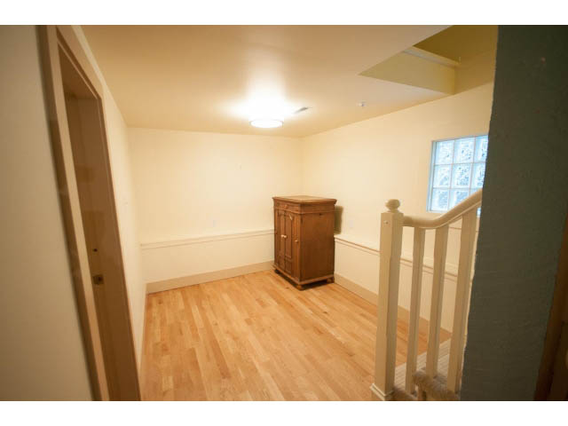 Bright living room with hardwood floors and a glass block window. - 3362 West 3rd Ave, Vancouver West Side