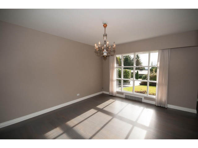 Spacious living room with hardwood floors and large windows, letting in natural light. - 555 Stevens Dr, West Vancouver