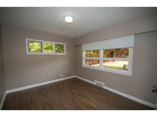 Bright living room with hardwood floors and large windows. - 555 Stevens Dr, West Vancouver