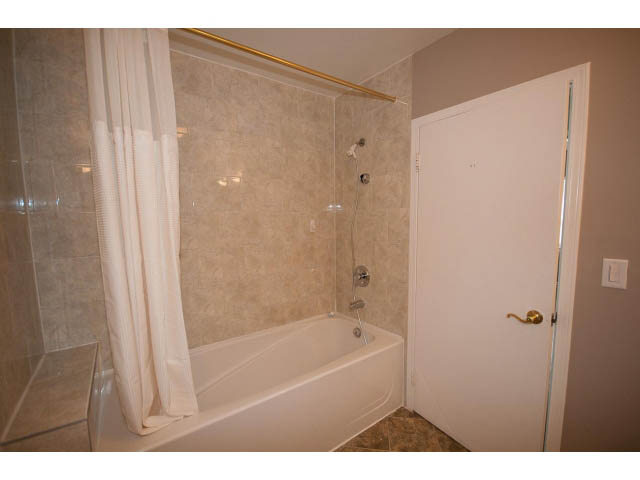 Bathroom with white fixtures and beige tile walls. - 555 Stevens Dr, West Vancouver