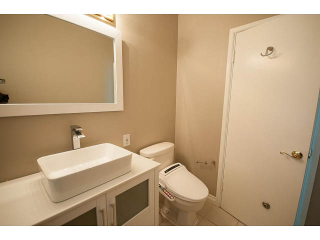 Bathroom with white sink, toilet, and mirror. - 555 Stevens Dr, West Vancouver