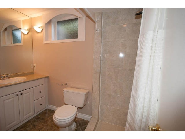 Bathroom with beige walls, white toilet, and tiled shower. - 555 Stevens Dr, West Vancouver