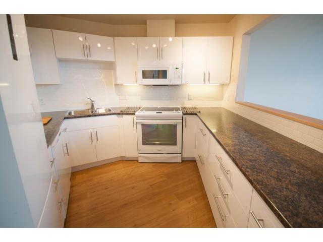 Bright kitchen with granite countertops, hardwood floors, and white cabinetry. - 14 - 1201 Lamey's Mill Rd., Vancouver West Side