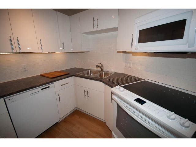 Bright kitchen with white cabinetry, granite countertops, and hardwood floors. - 14 - 1201 Lamey's Mill Rd., Vancouver West Side