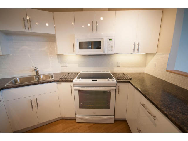 Bright kitchen with white cabinets, granite countertops, and hardwood floors. - 14 - 1201 Lamey's Mill Rd., Vancouver West Side