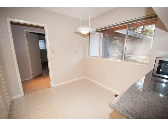 Bright kitchen with granite countertops and sliding glass doors leading to a patio. - 610 Newdale Rd., West Vancouver