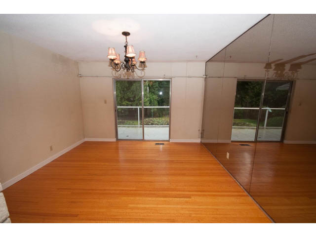 Spacious living room with hardwood floors and a chandelier, large windows offering a view. - 610 Newdale Rd., West Vancouver