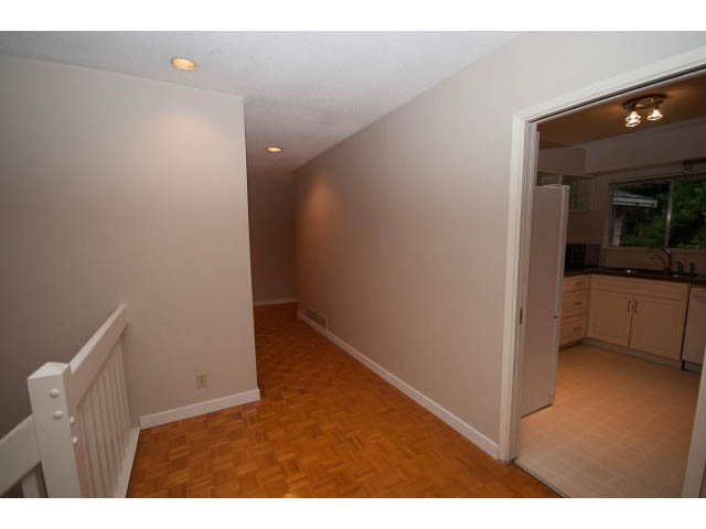 Bright living room with hardwood floors and kitchen in the background. - 610 Newdale Rd., West Vancouver