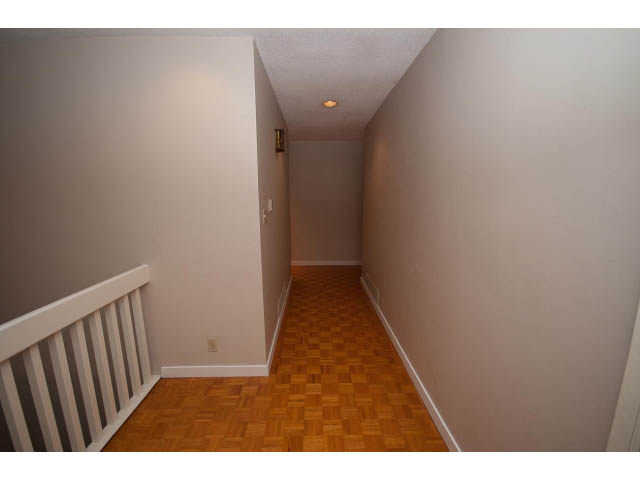 Narrow hallway with parquet flooring and white walls. - 610 Newdale Rd., West Vancouver